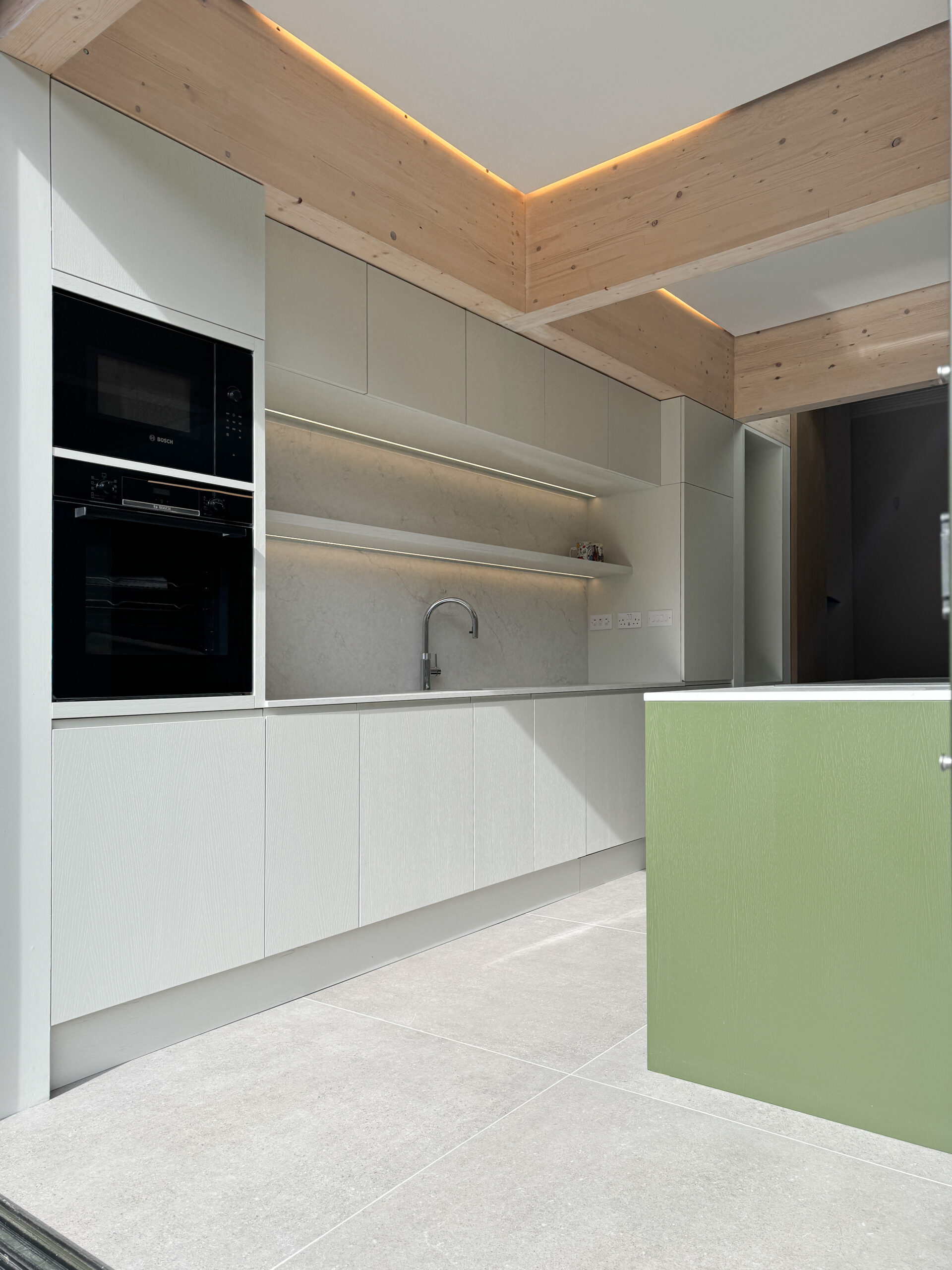 Custom made modern kitchen and utility space with large island, quartz worktop, hidden doors