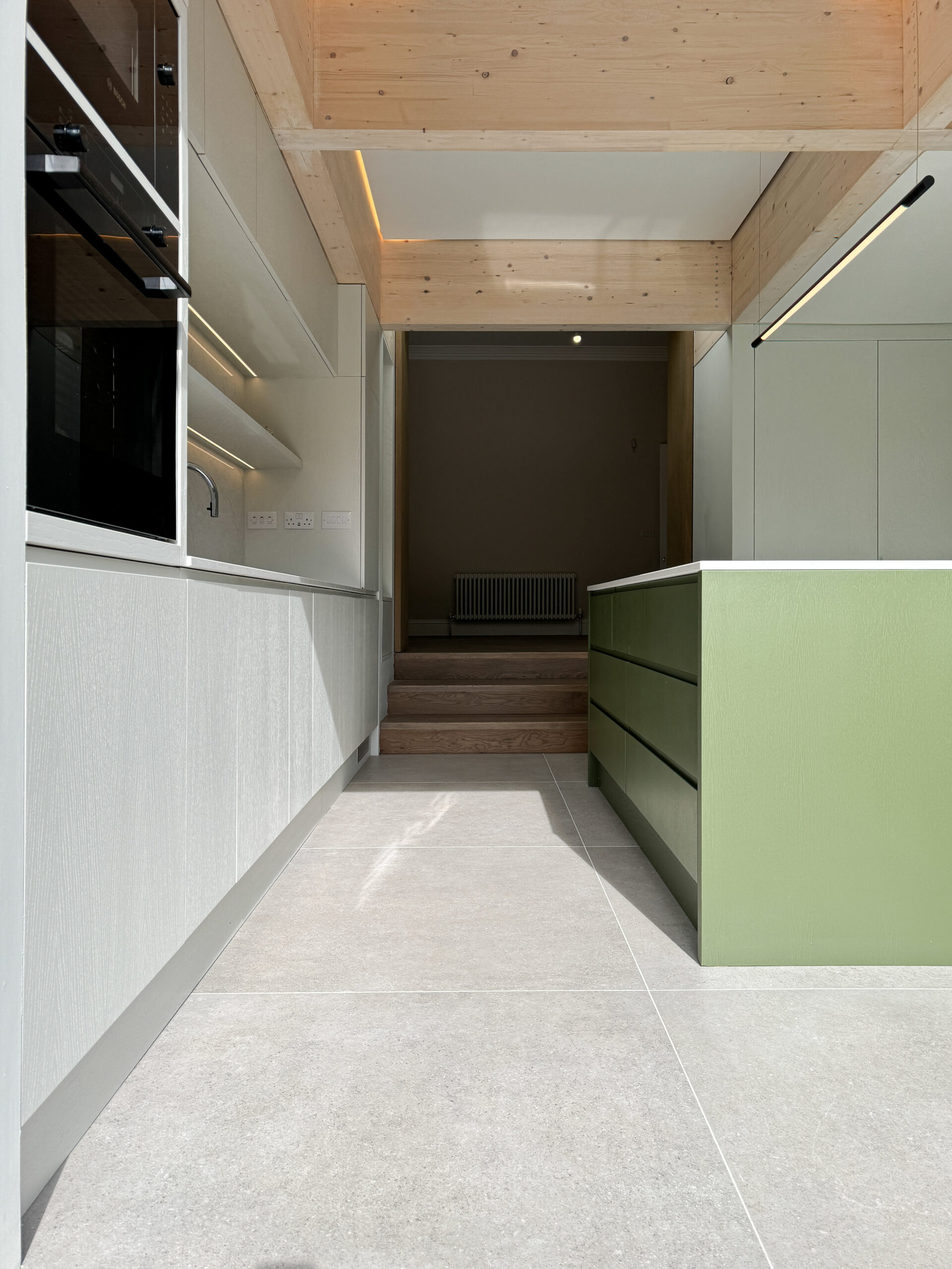 Custom made modern kitchen and utility space with large island, quartz worktop, hidden doors