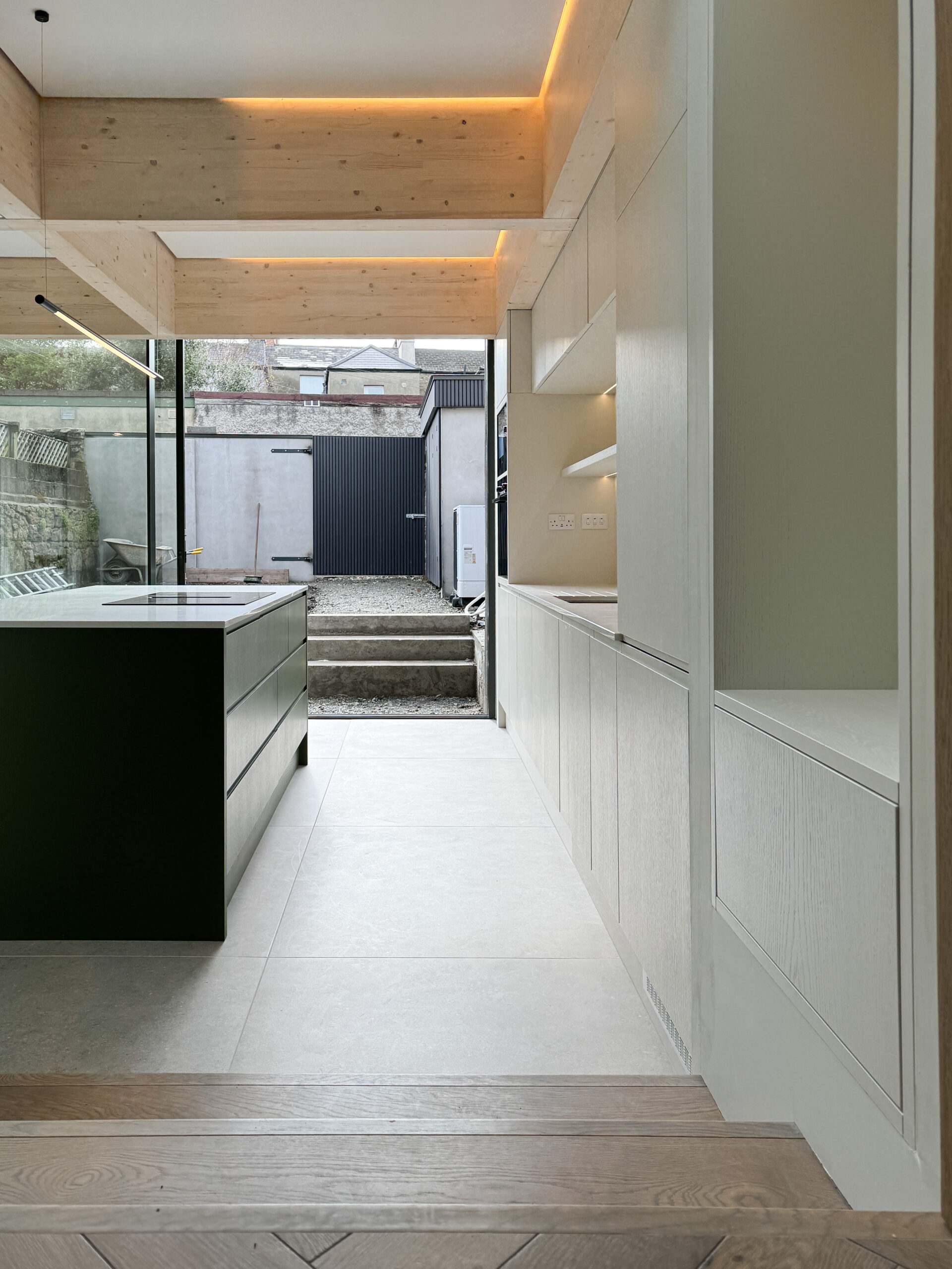 Custom made modern kitchen and utility space with large island, quartz worktop, hidden doors