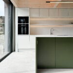 Custom made modern kitchen and utility space with large island, quartz worktop, hidden doors