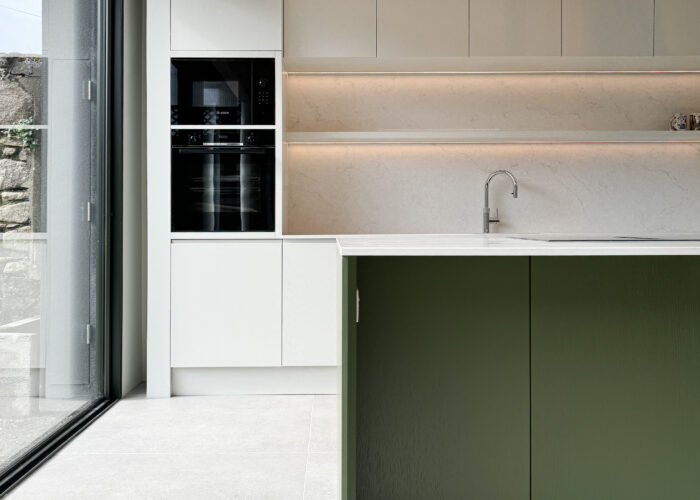 Custom made modern kitchen and utility space with large island, quartz worktop, hidden doors