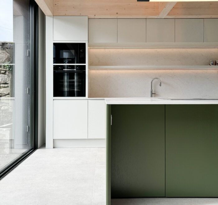 Custom made modern kitchen and utility space with large island, quartz worktop, hidden doors