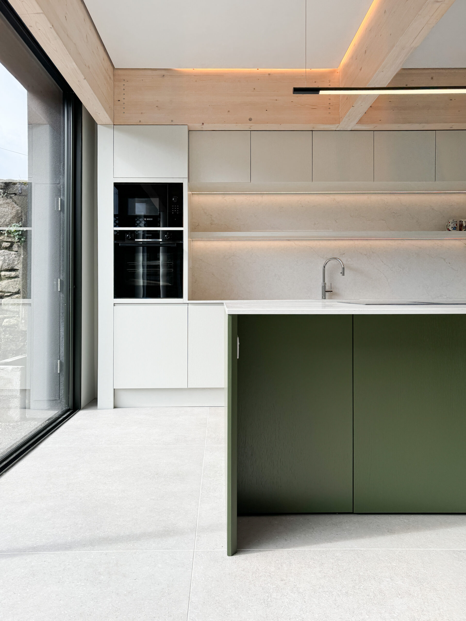 Custom made modern kitchen and utility space with large island, quartz worktop, hidden doors