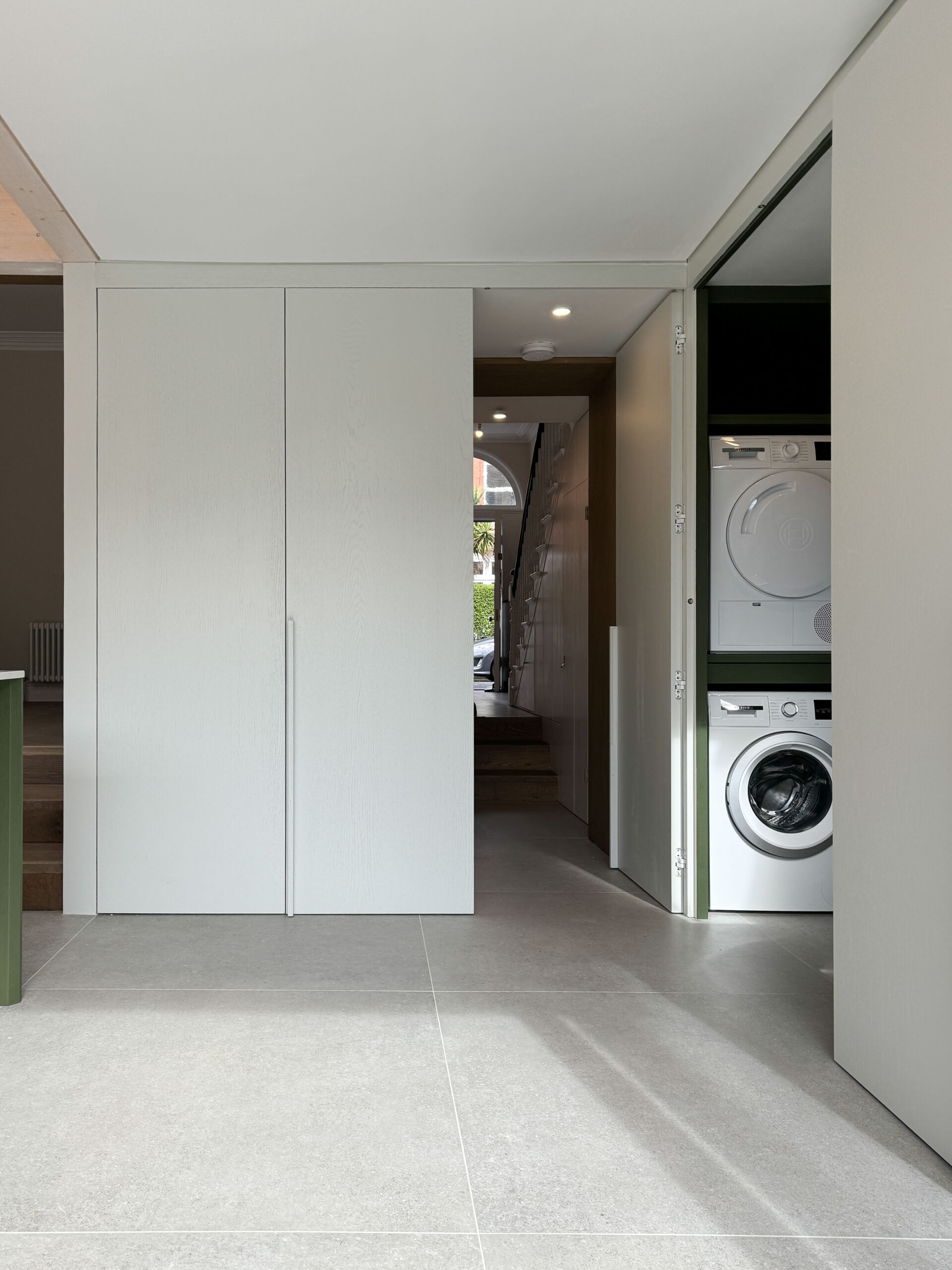 Custom made modern kitchen and utility space with large island, quartz worktop, hidden doors