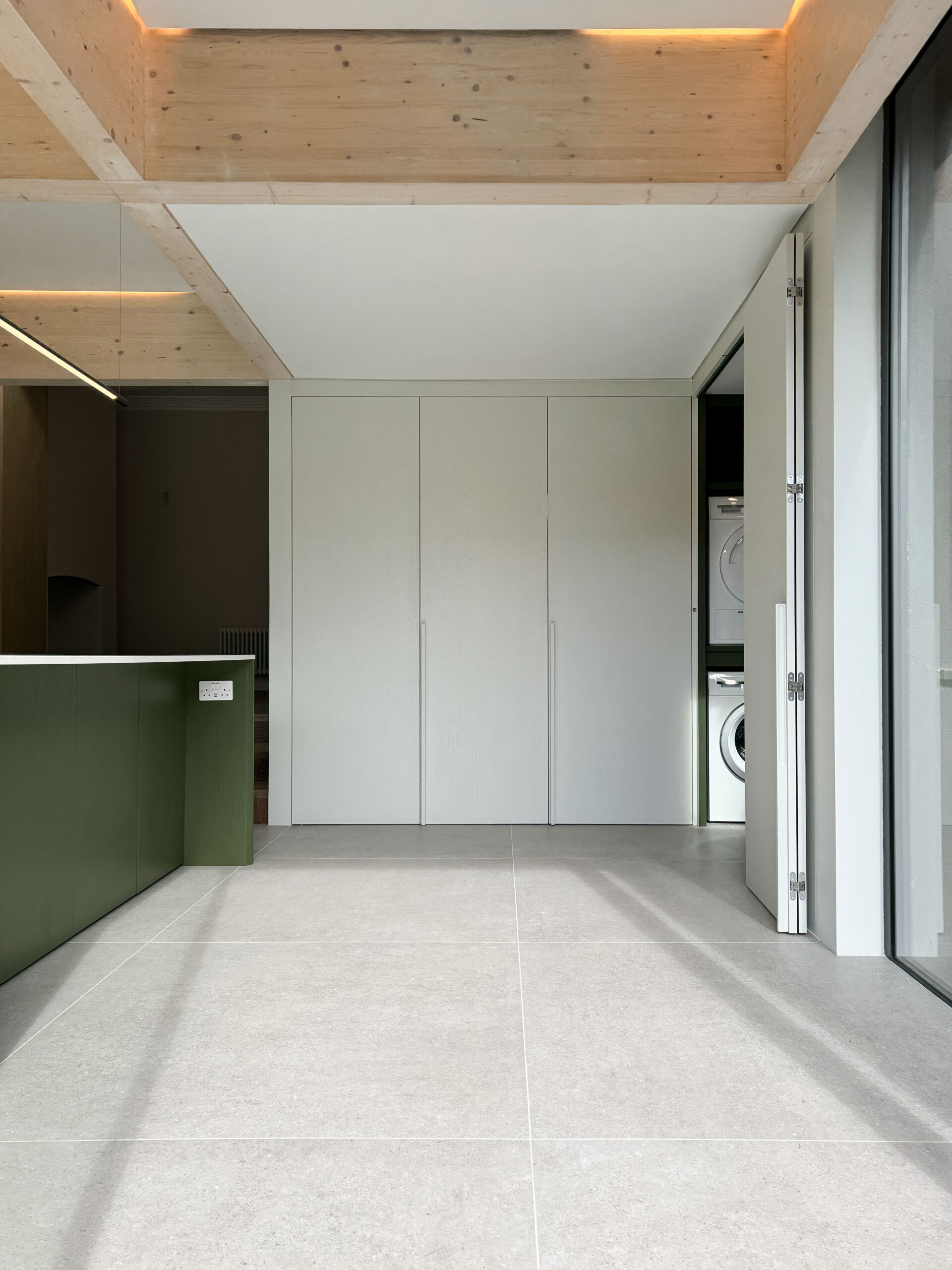 Custom made modern kitchen and utility space with large island, quartz worktop, hidden doors