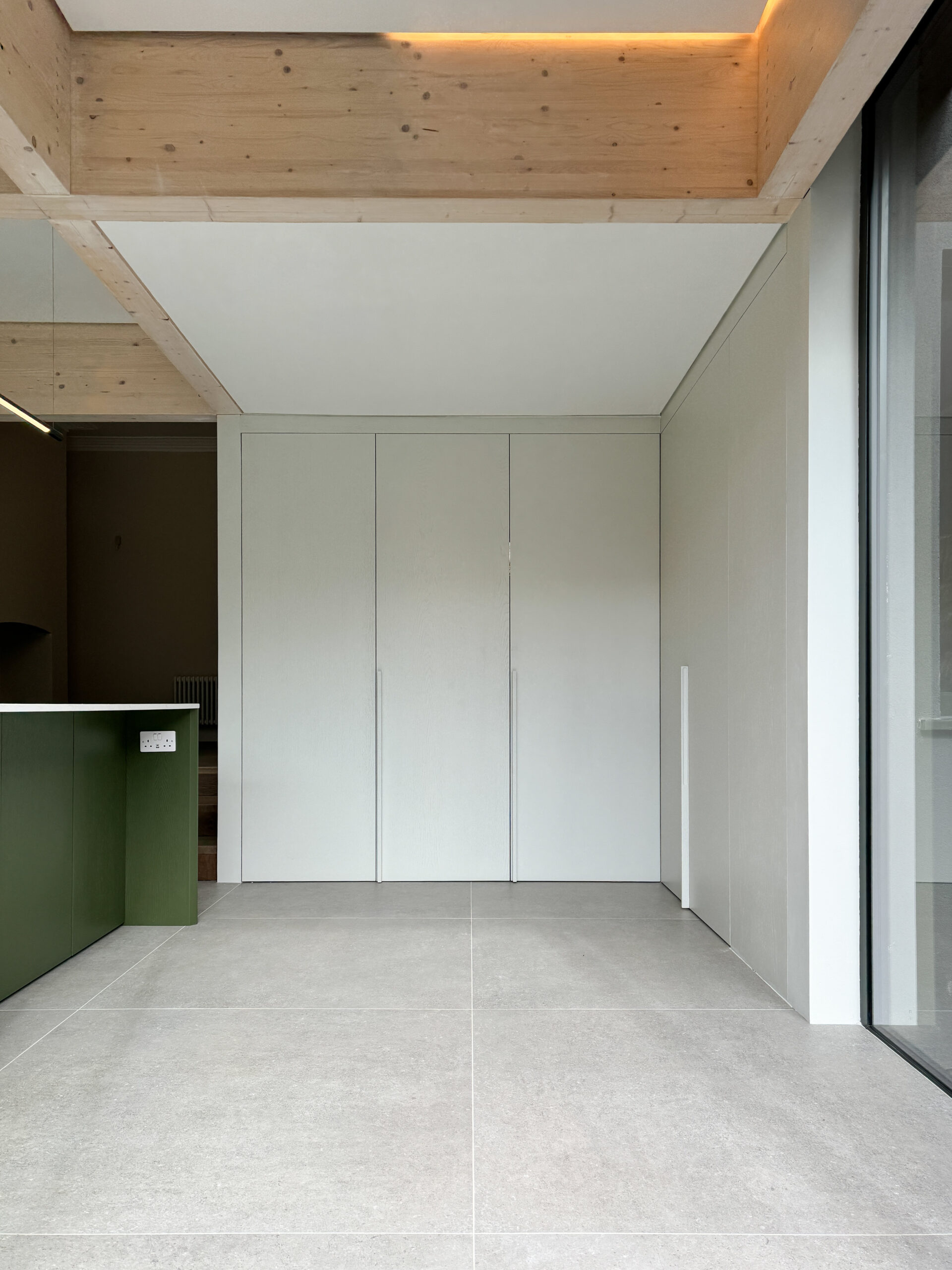 Custom made modern kitchen and utility space with large island, quartz worktop, hidden doors
