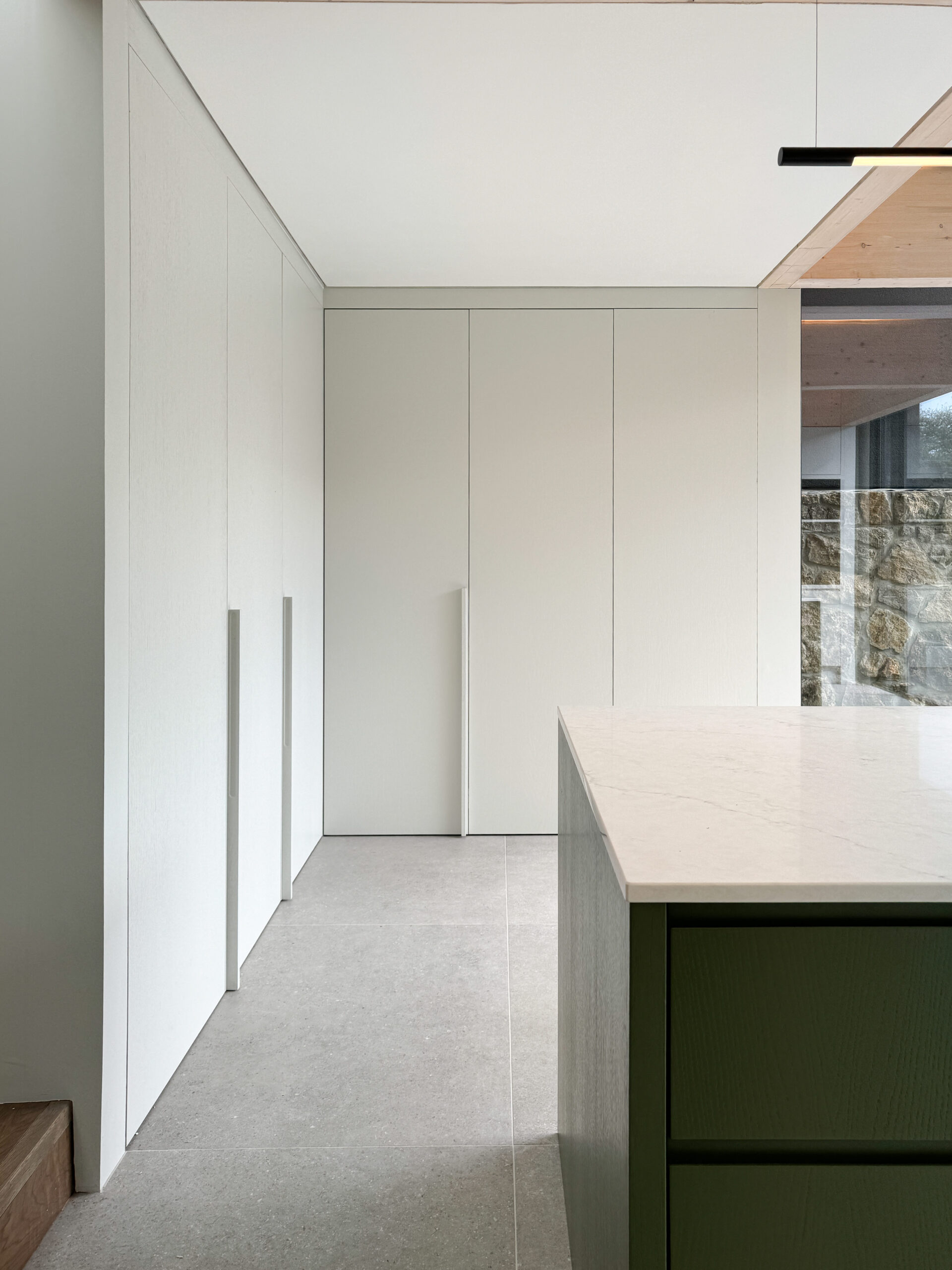 Custom made modern kitchen and utility space with large island, quartz worktop, hidden doors
