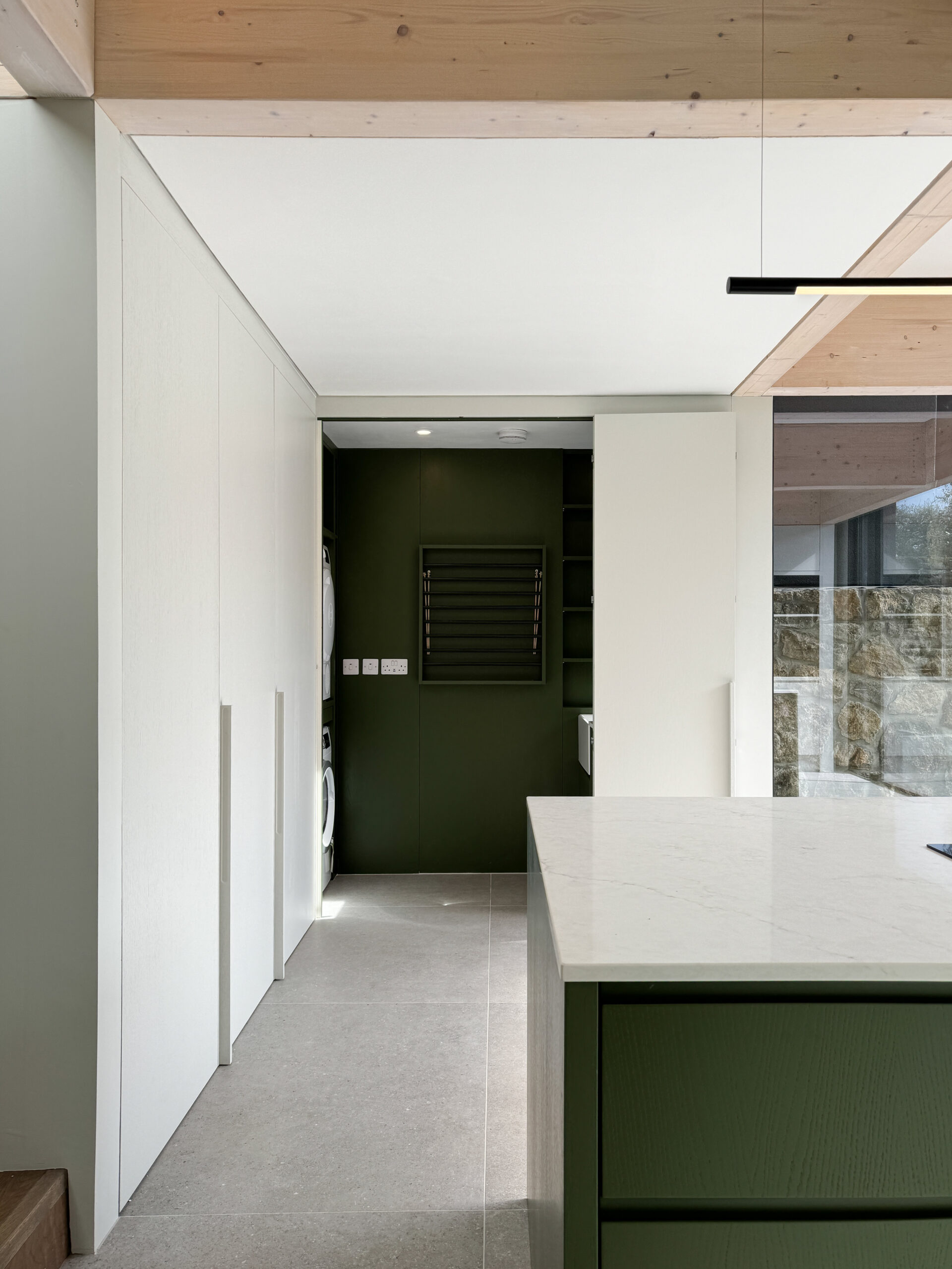 Custom made modern kitchen and utility space with large island, quartz worktop, hidden doors