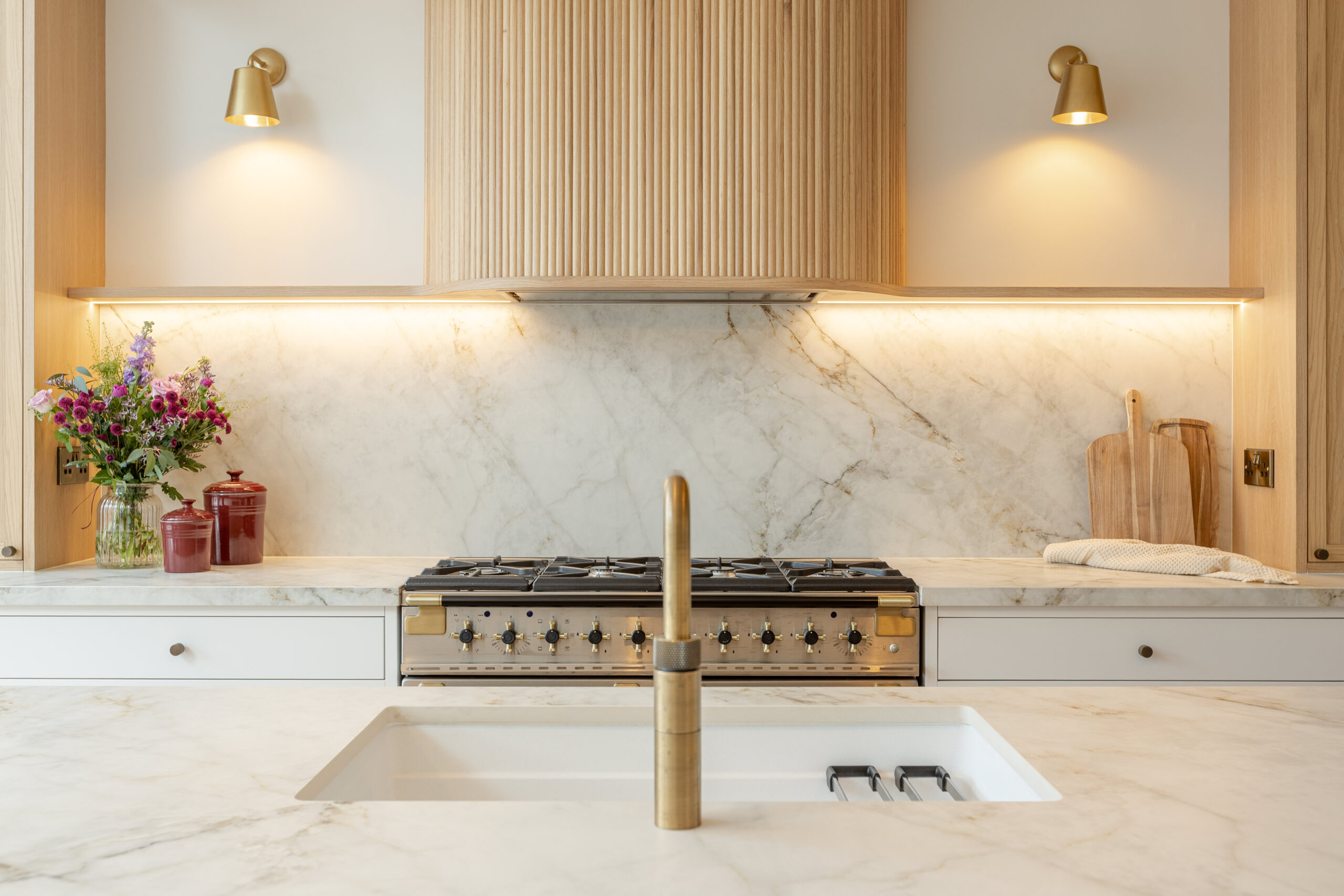 Custom made modern classical kitchen with large island, quartz worktop, and pendant lights and warm wood touch