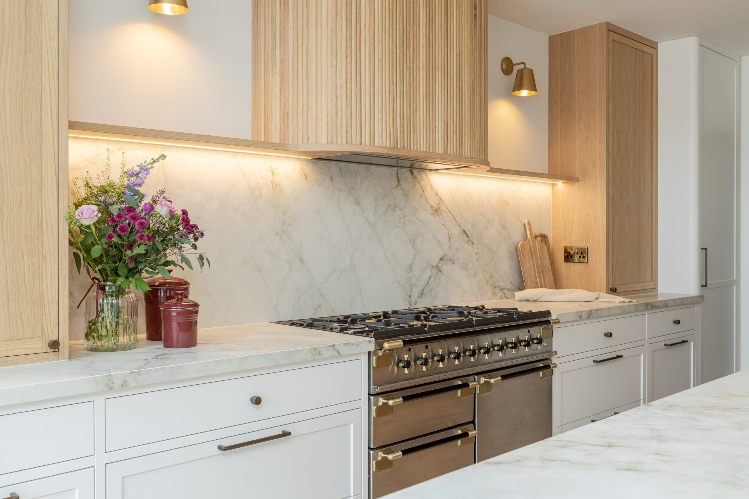 Custom made modern classical kitchen with large island, quartz worktop, and pendant lights and warm wood touch