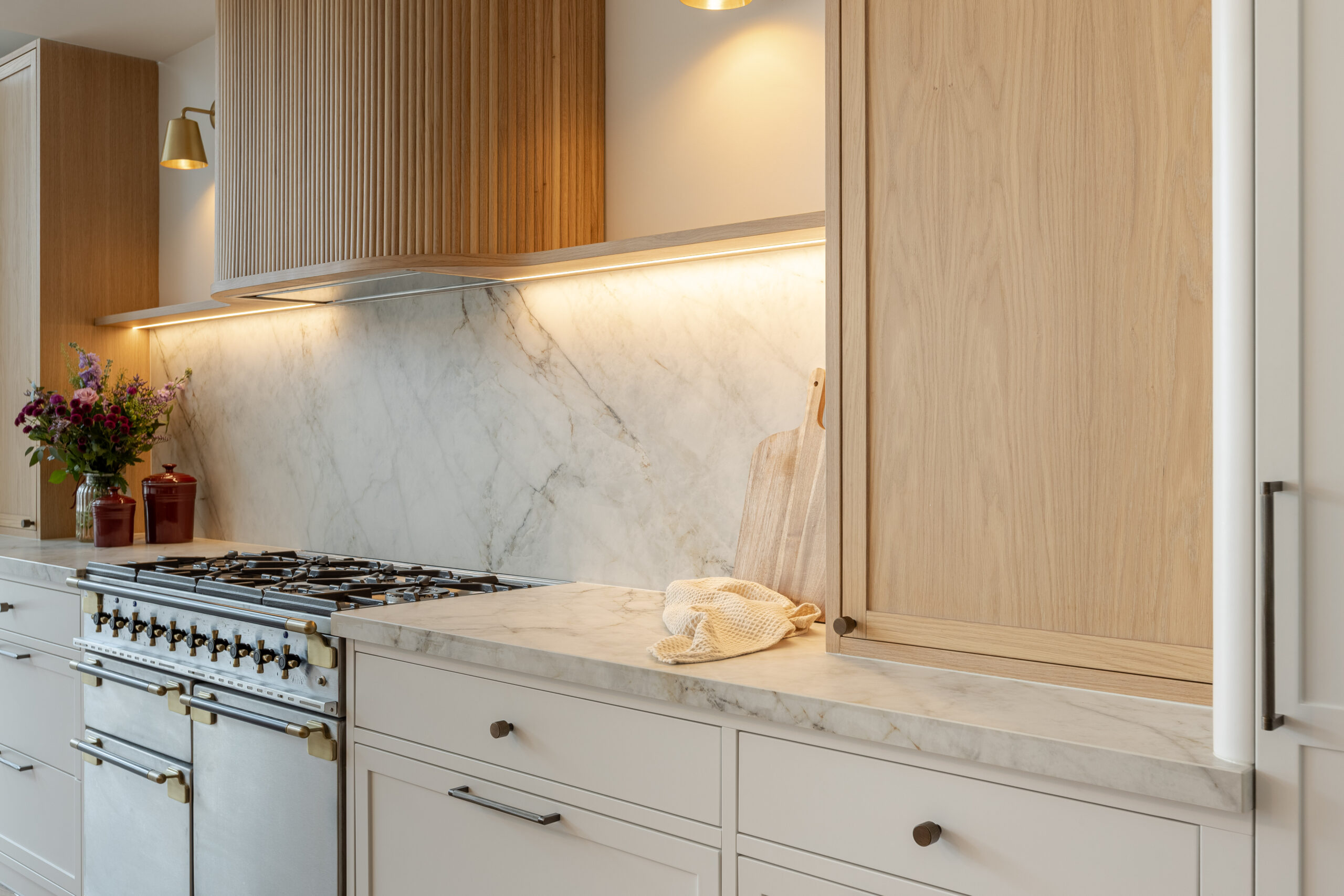 Custom made modern classical kitchen with large island, quartz worktop, and pendant lights and warm wood touch