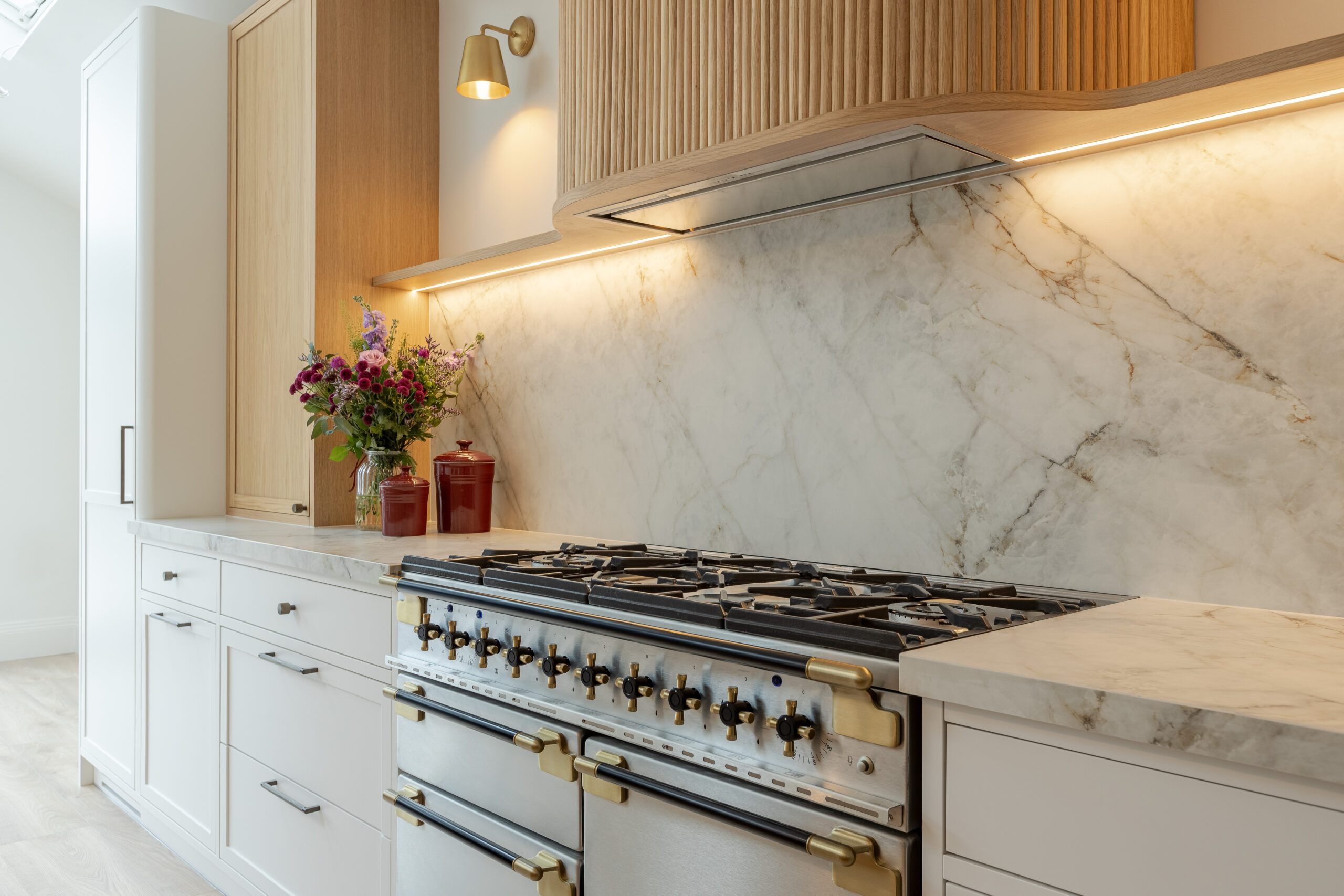 Custom made modern classical kitchen with large island, quartz worktop, and pendant lights and warm wood touch