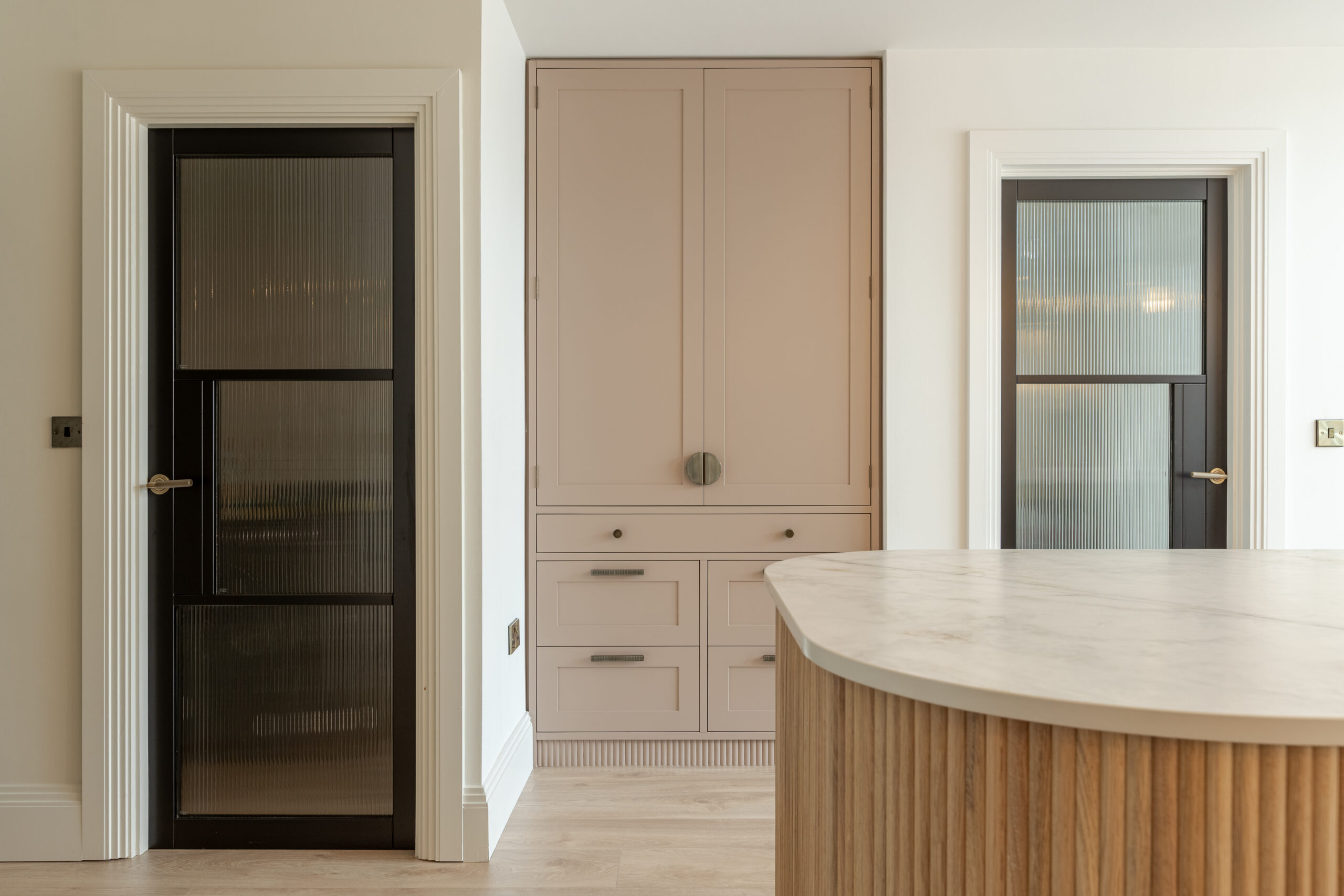 Custom made modern classical kitchen with large island, quartz worktop, and pendant lights and warm wood touch
