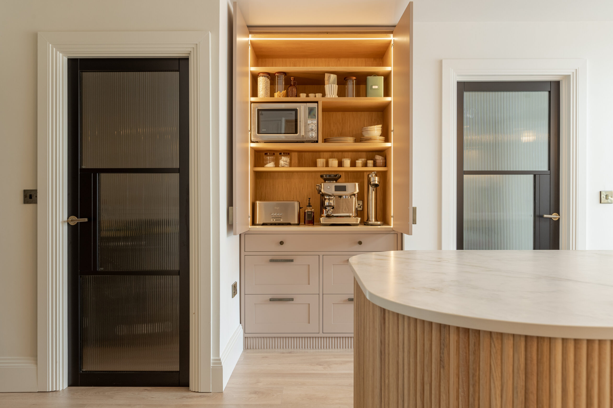 Custom made modern classical kitchen with large island, quartz worktop, and pendant lights and warm wood touch