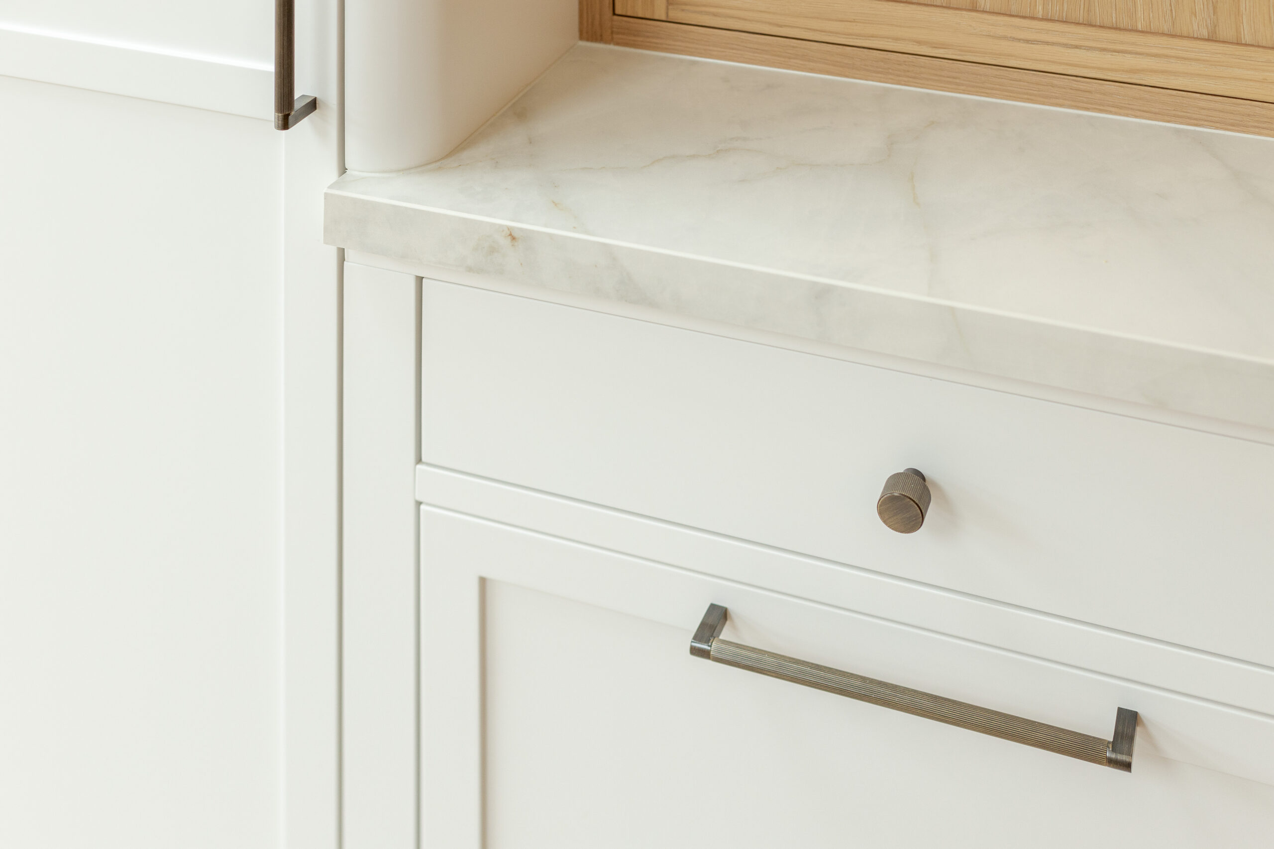 Custom made modern classical kitchen with large island, quartz worktop, and pendant lights and warm wood touch