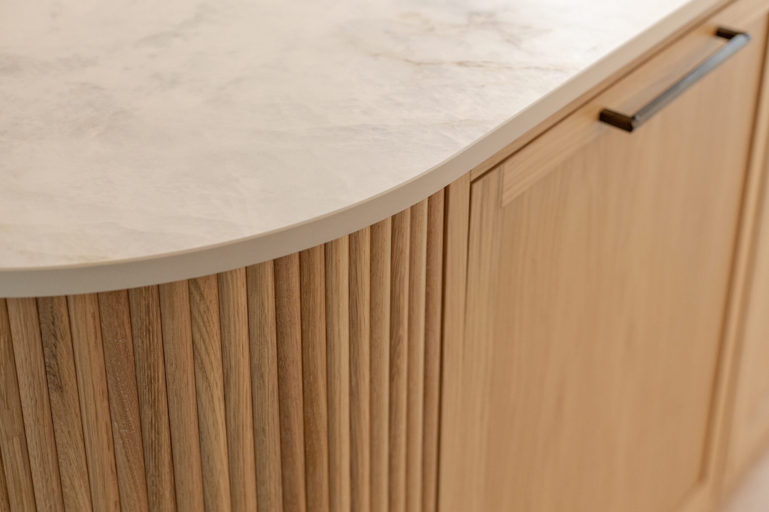 Custom made modern classical kitchen with large island, quartz worktop, and pendant lights and warm wood touch