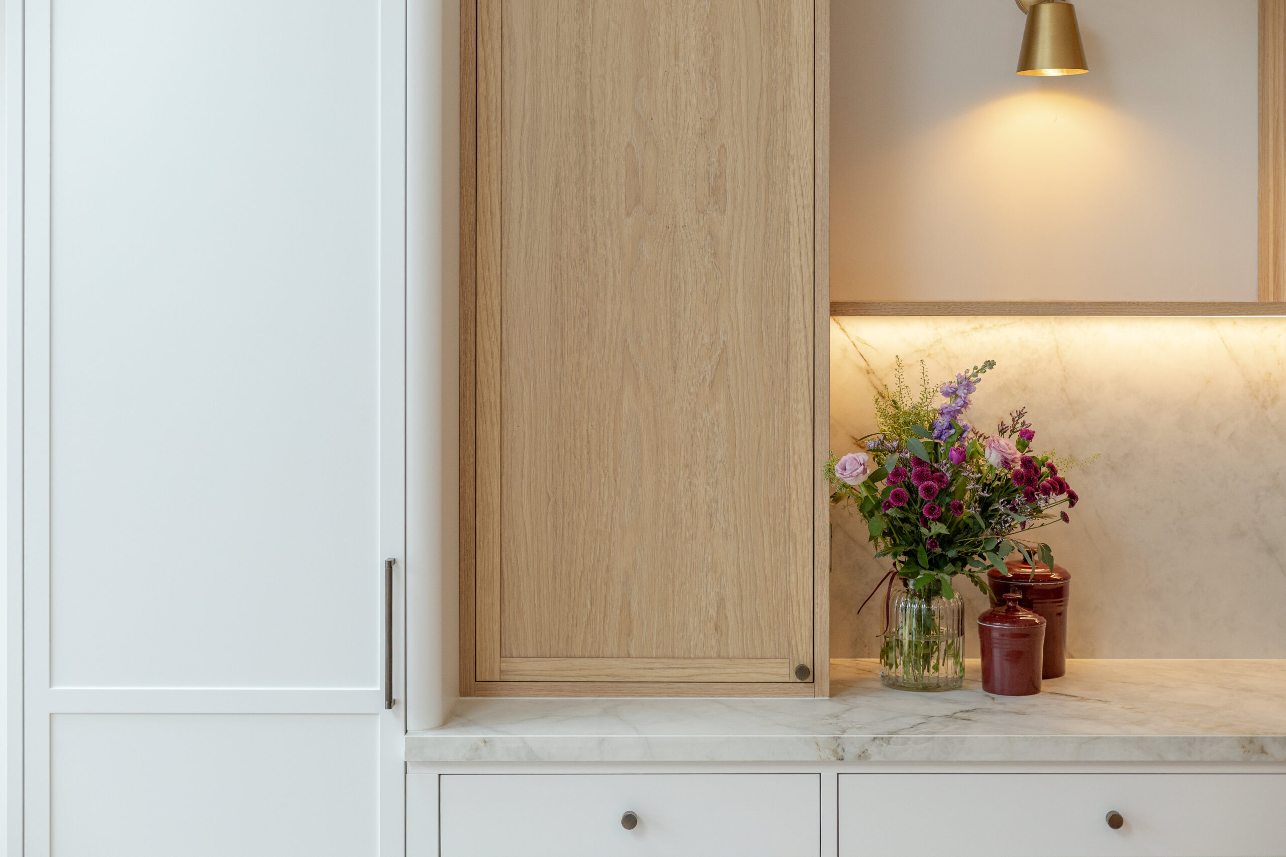 Custom made modern classical kitchen with large island, quartz worktop, and pendant lights and warm wood touch