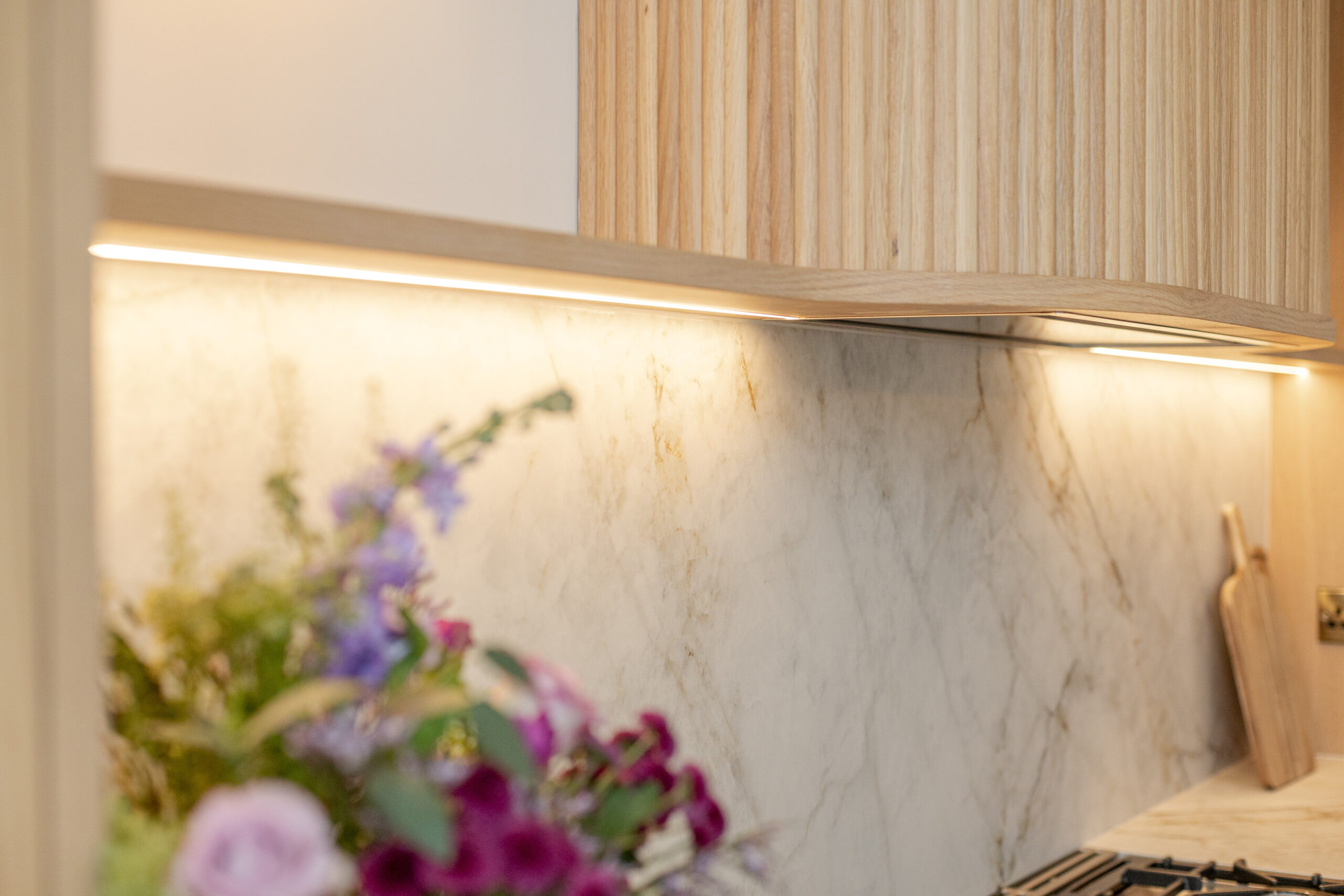 Custom made modern classical kitchen with large island, quartz worktop, and pendant lights and warm wood touch