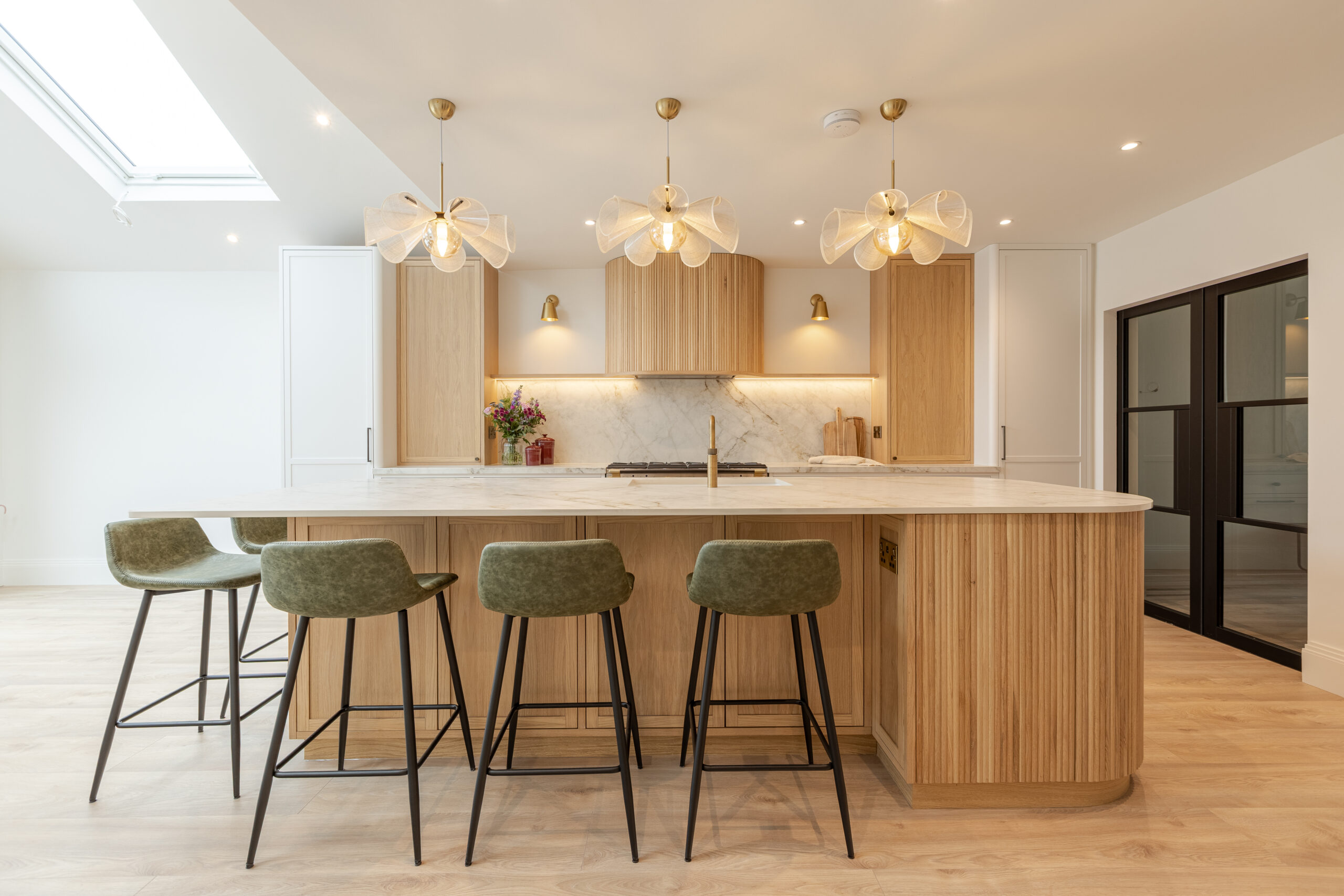 Custom made modern classical kitchen with large island, quartz worktop, and pendant lights and warm wood touch