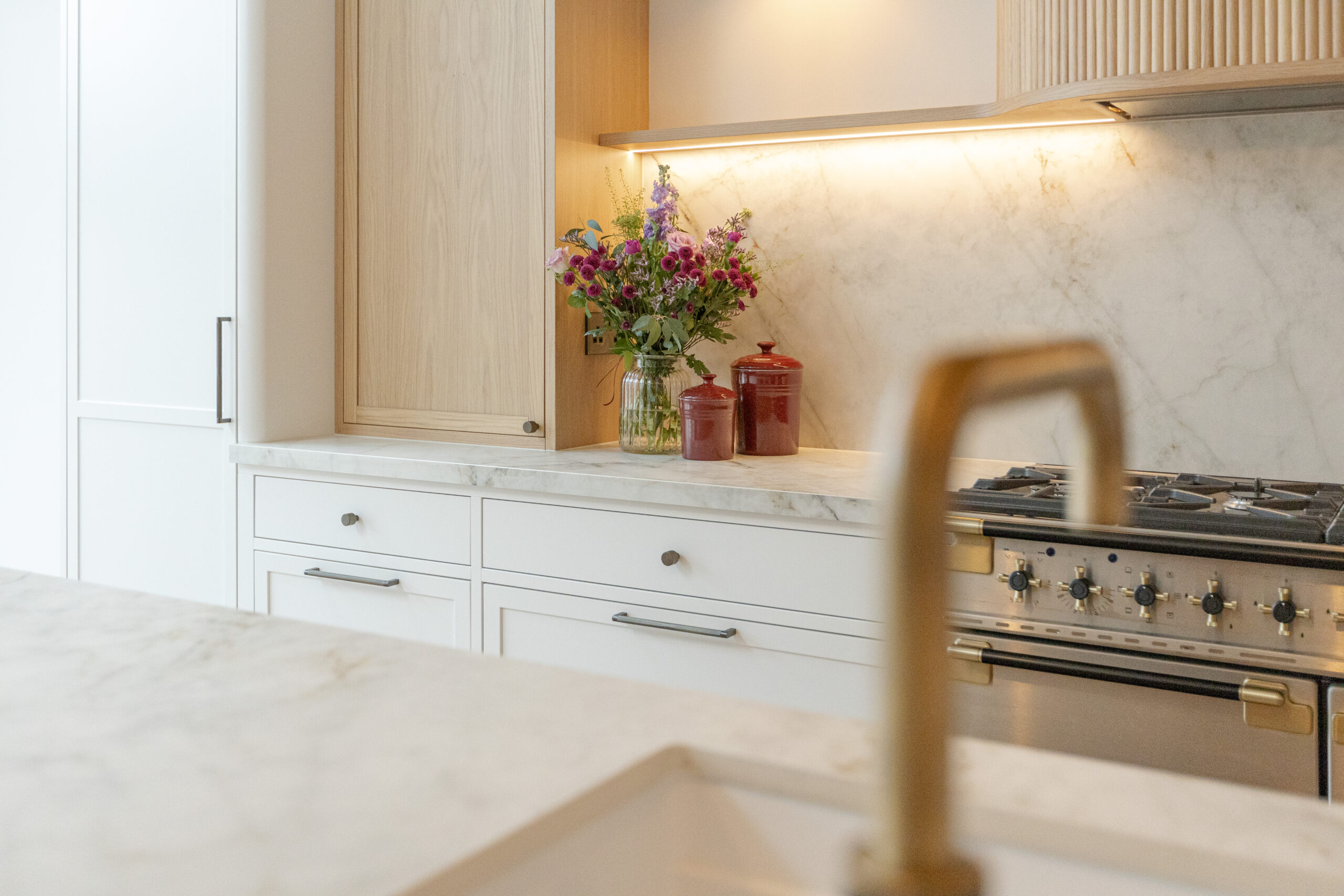 Custom made modern classical kitchen with large island, quartz worktop, and pendant lights and warm wood touch