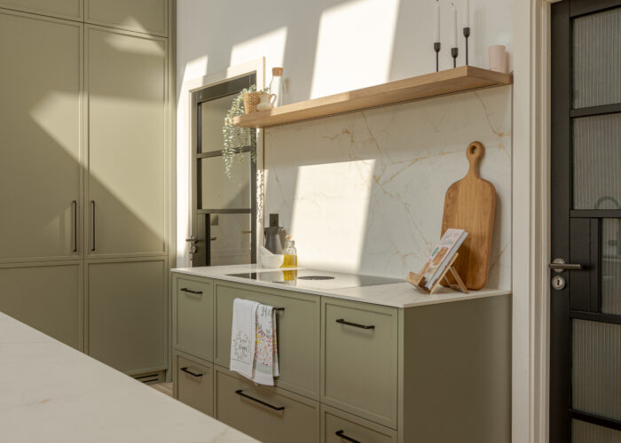 A refined modern classic kitchen combining timeless shaker cabinetry with contemporary finishes and natural warmth.