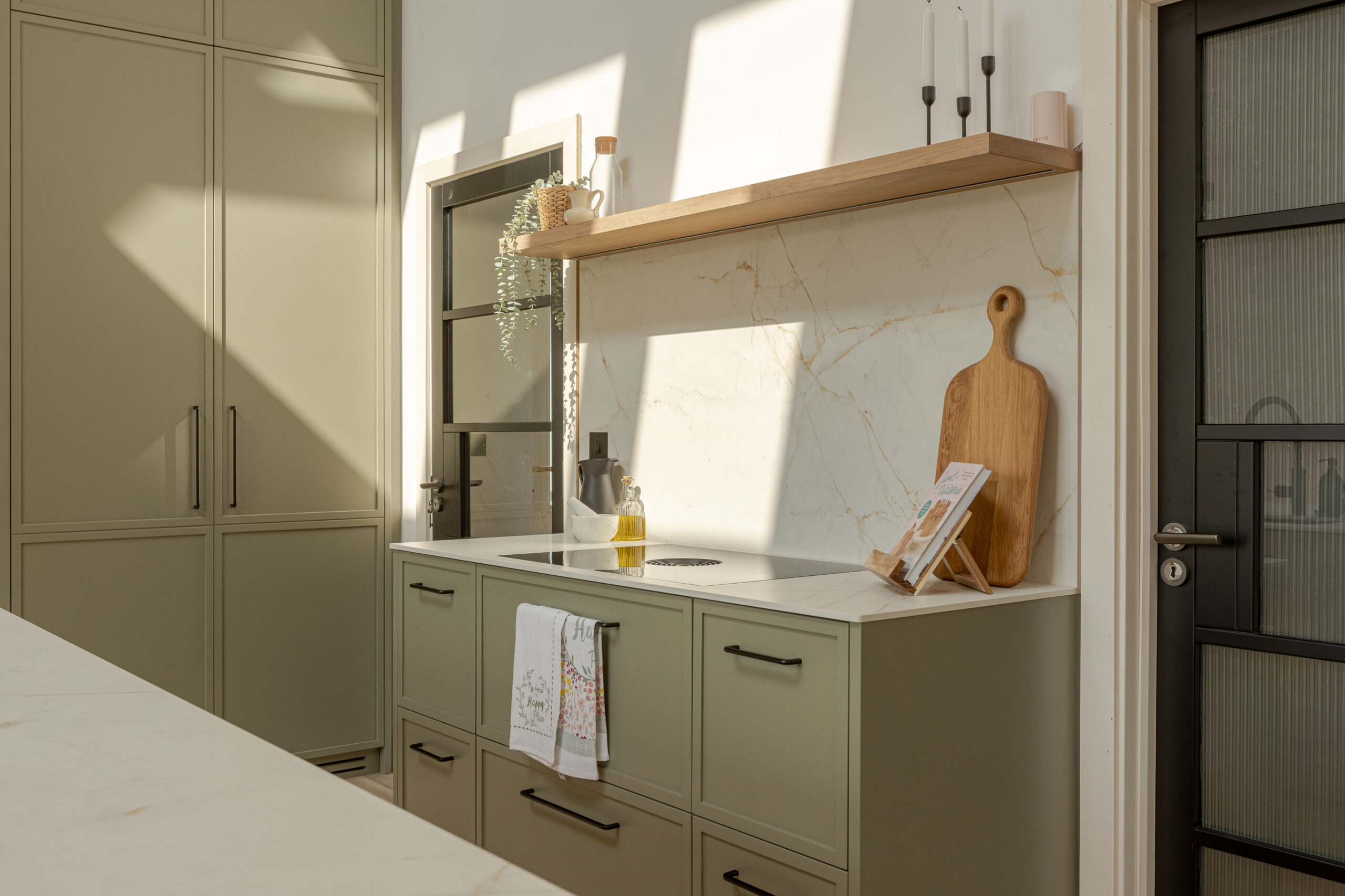 A refined modern classic kitchen combining timeless shaker cabinetry with contemporary finishes and natural warmth.