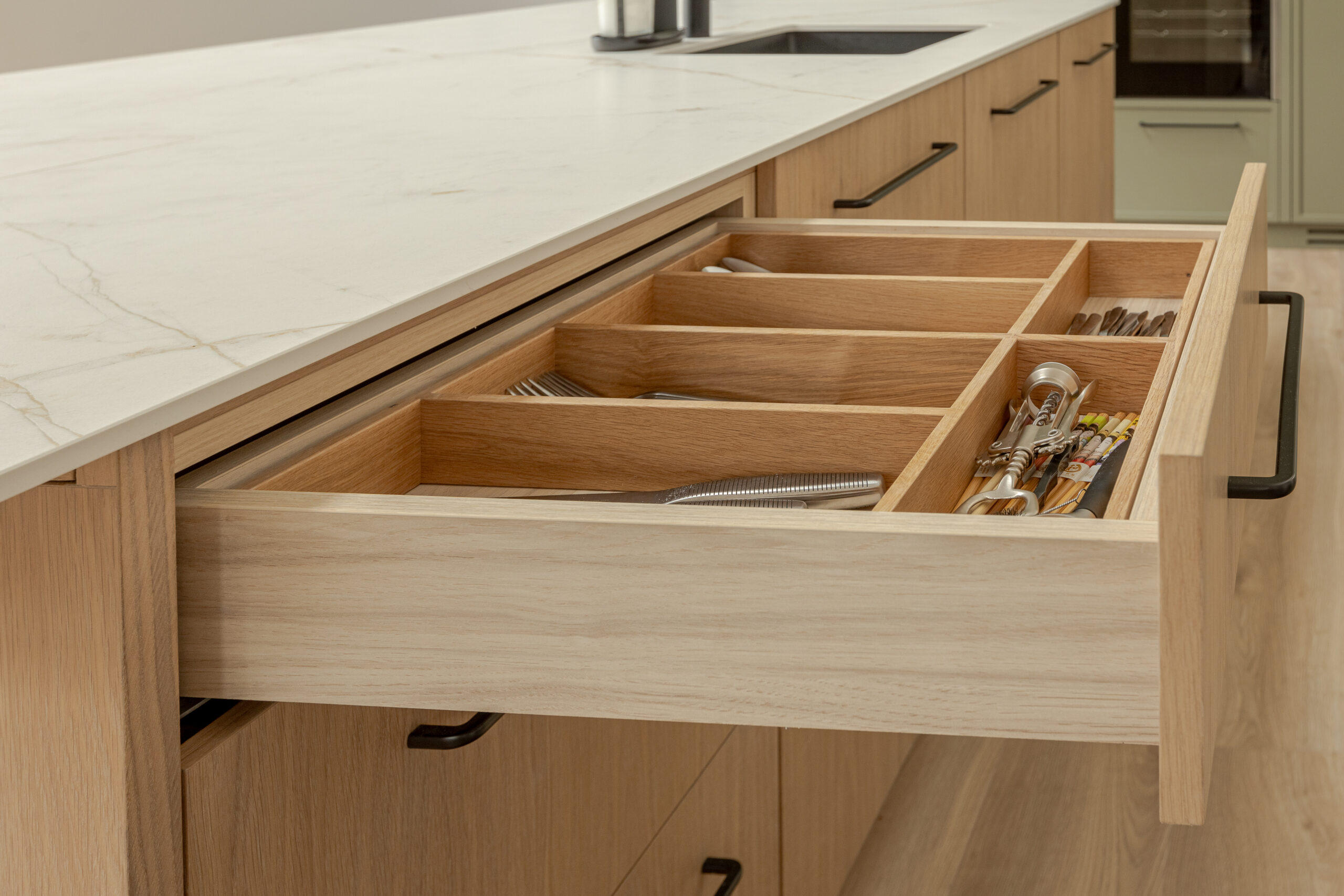 A refined modern classic kitchen combining timeless shaker cabinetry with contemporary finishes and natural warmth.