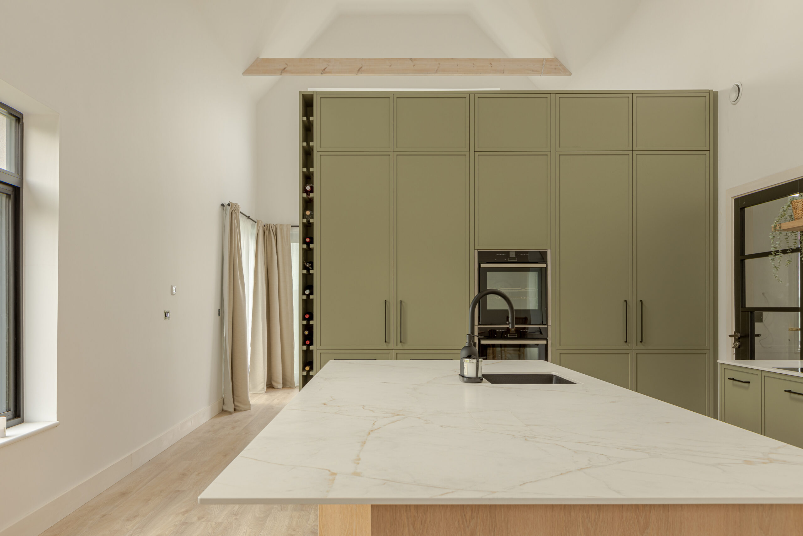 A refined modern classic kitchen combining timeless shaker cabinetry with contemporary finishes and natural warmth.